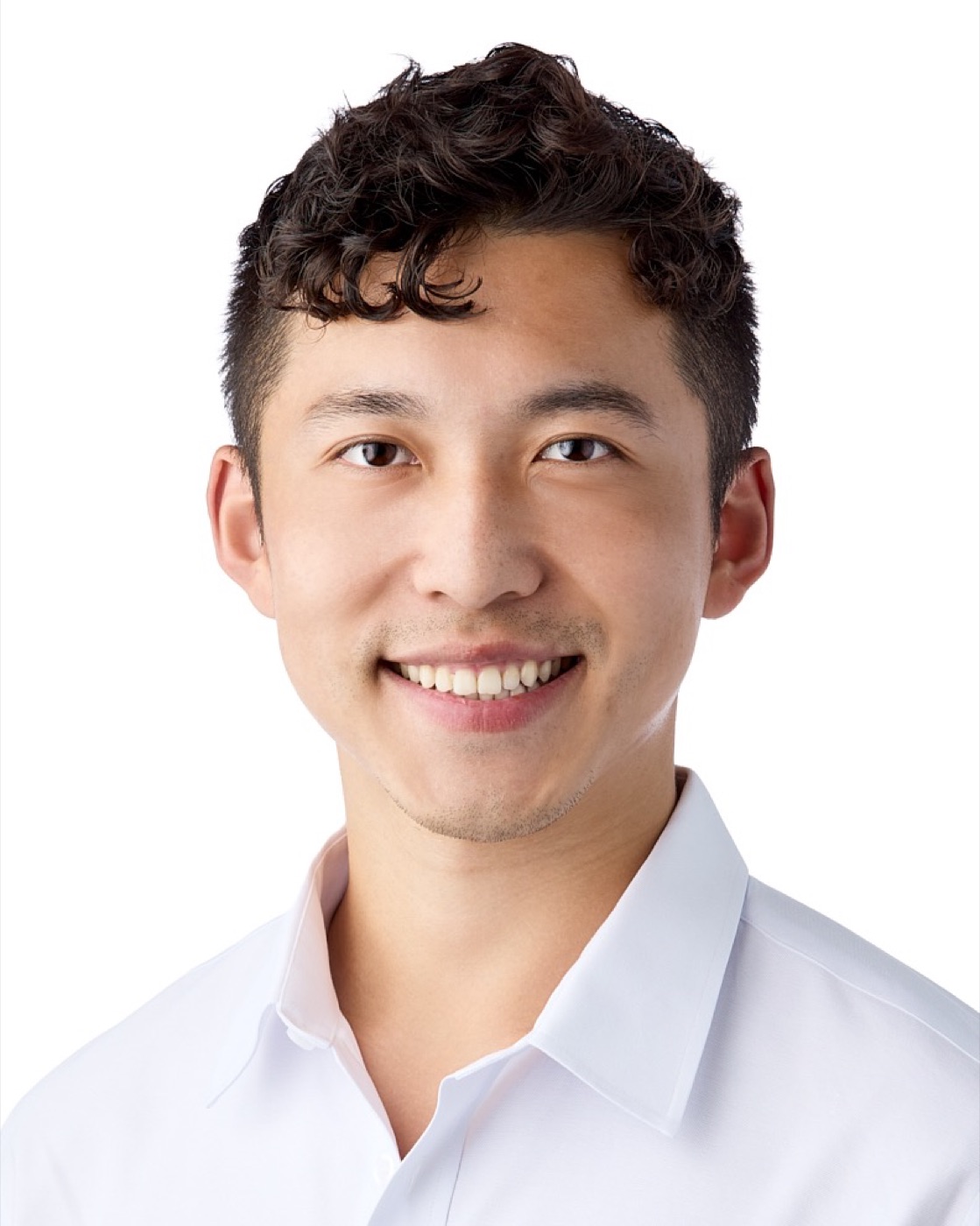 Business-casual headshot of a man in a white shirt on white