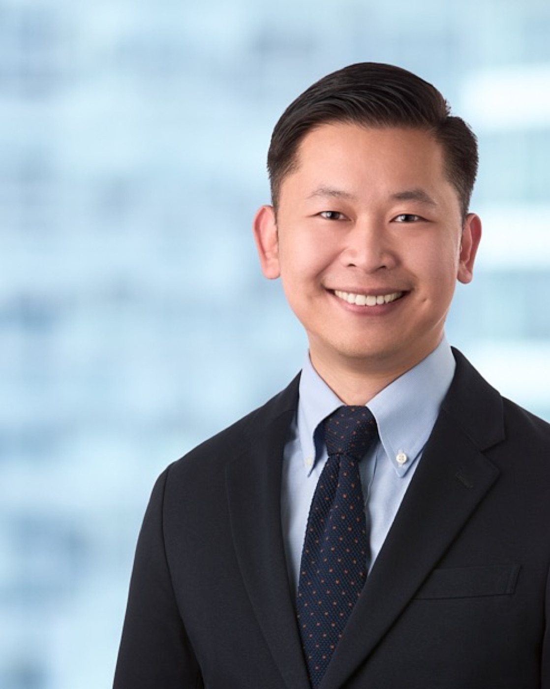 Corporate headshot of a man in a suit, bright background