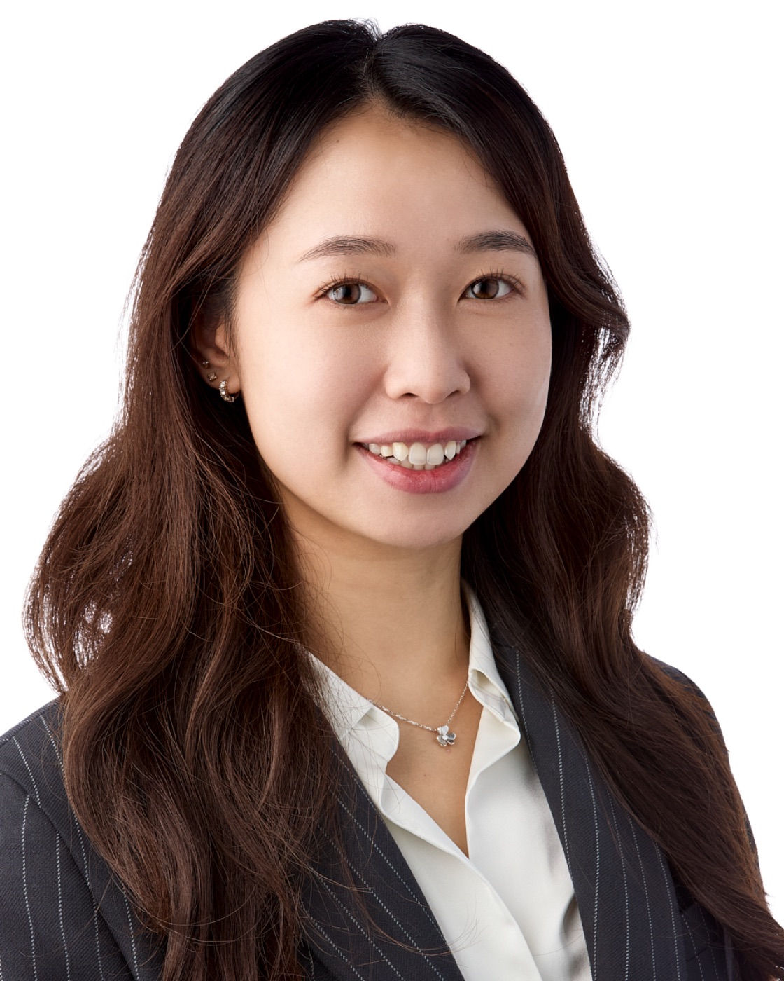 Studio headshot of a woman with soft waves in a cream blouse, natural makeup