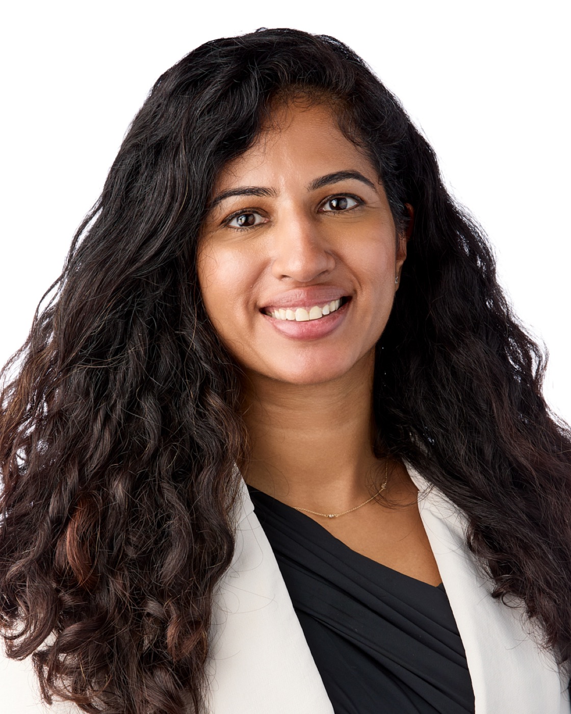 Corporate headshot of a woman in a white blazer on a white background