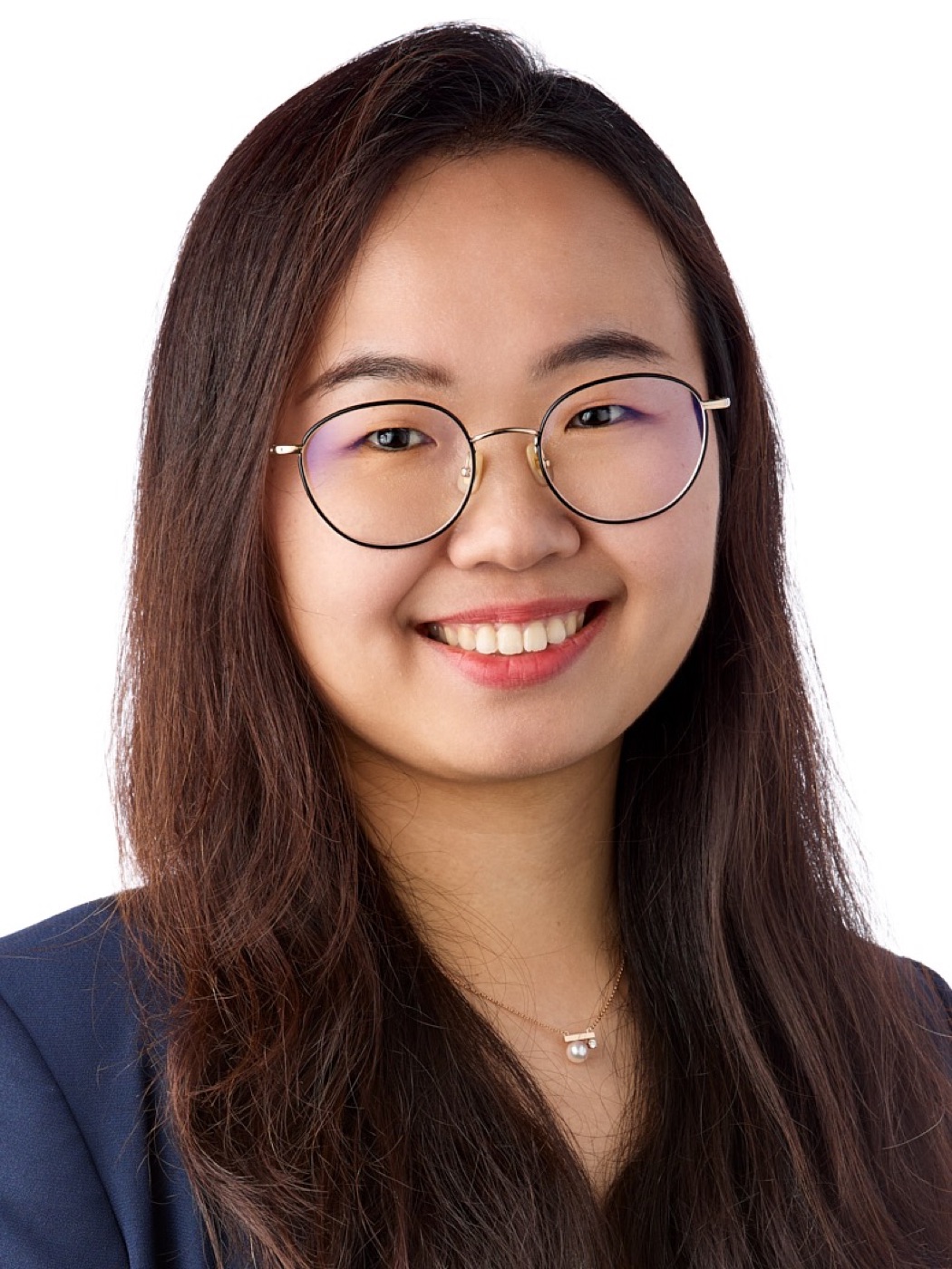 Corporate headshot of a woman in a navy blazer and glasses on white