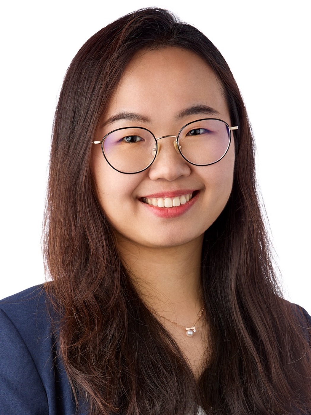 Corporate headshot of a woman in a navy blazer and glasses on white