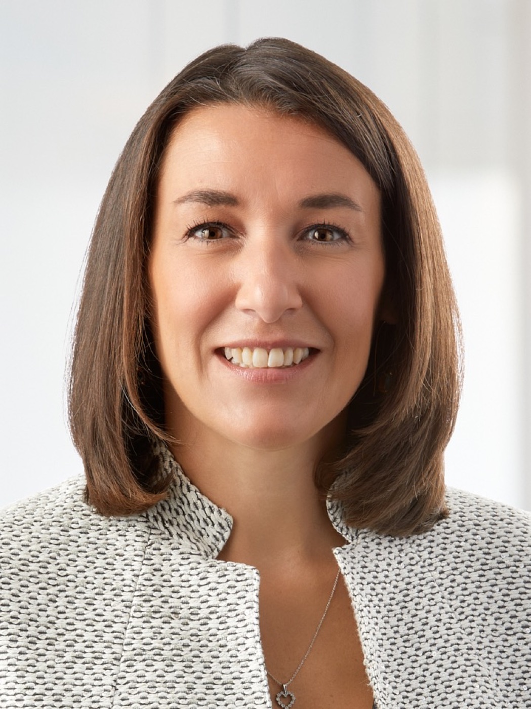Corporate headshot of a woman in a textured jacket, refined studio look